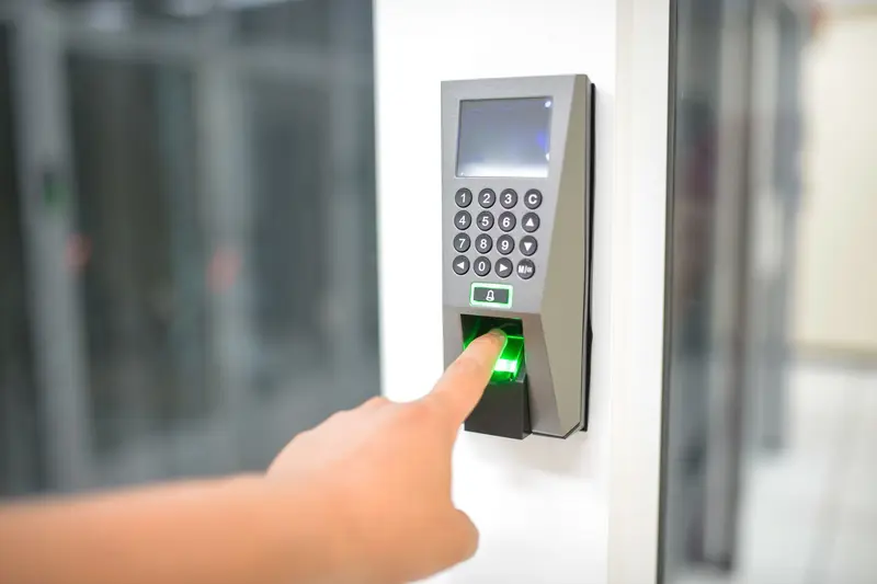 Finger placed on a fingerprint reader mounted on a wall