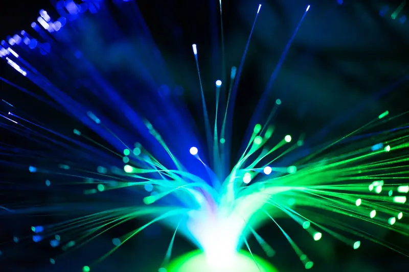 Optical fibers glowing with blue and green points of light