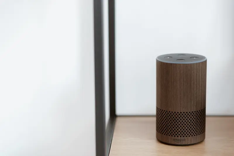 Cylindrical wooden smart speaker on a shelf