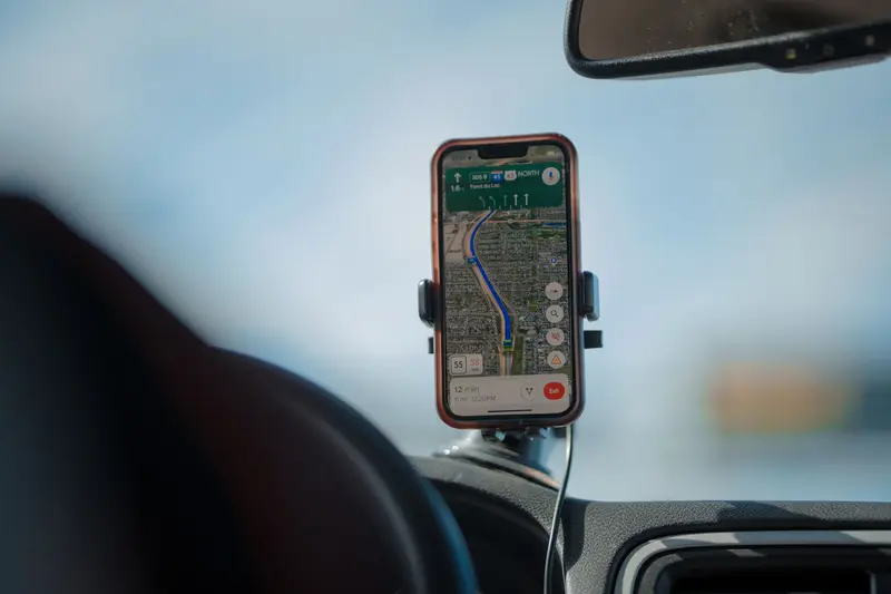 Smartphone showing a navigation map mounted on a car windshield