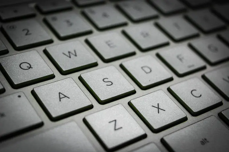 Close-up of keyboard keys showing the letters Q, W, E, A, S and Z on a gray surface